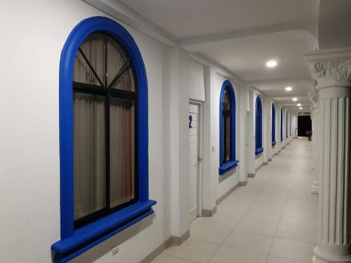 a hallway with blue windows in a building at Hotel Las Palmas de OSA in Ciudad Cortés