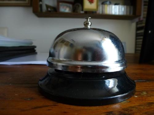 a metal bell sitting on a wooden table at B&B A Casa di Mael in San Costanzo
