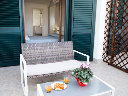 a white bench on a patio with a table with food at Villa Ulivi B&B in Pontecagnano