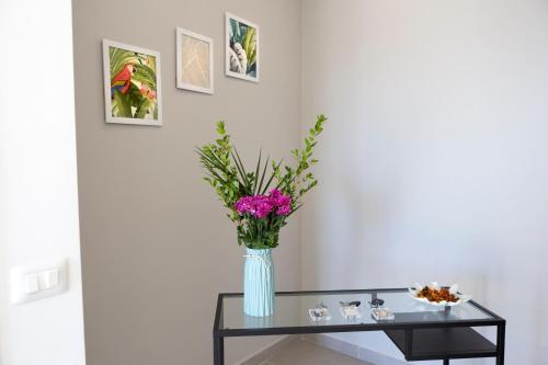 a vase with pink flowers on a glass table at Villa Ulivi B&B in Pontecagnano
