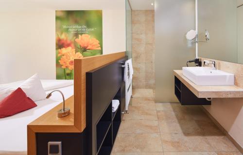 a bathroom with a sink and a bed at Landhotel Wilder Mann in Eggingen