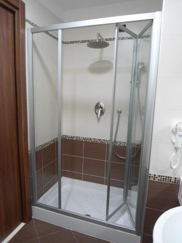 a shower with a glass door in a bathroom at Hotel Continental in Turin