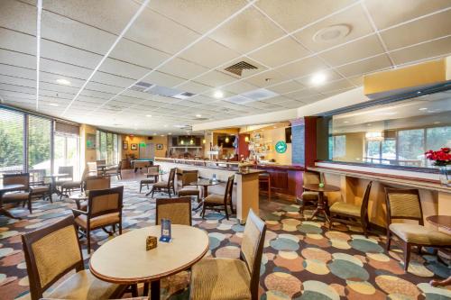 a restaurant with tables and chairs and a bar at Chester Hotel and Conference Center in Exton