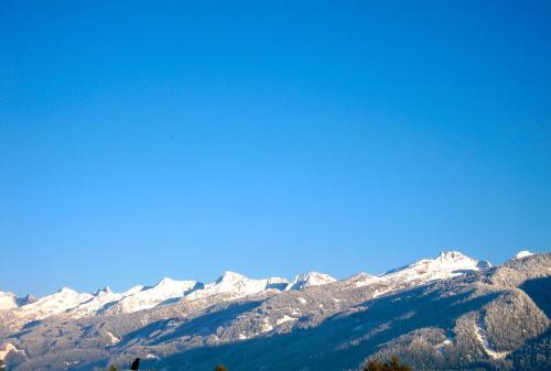 a snow covered mountain range with a blue sky at Albergo Bellaria in Carano