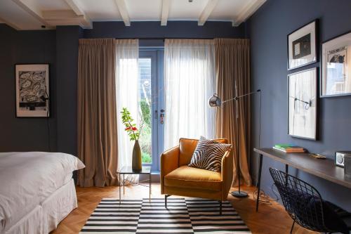 1 dormitorio con 1 cama, 1 silla y 1 ventana en suite no 7, en Ámsterdam