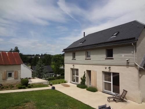 a white house with a black roof and a yard at An Hütten in Herresbach