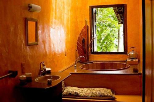 a bathroom with two sinks and a window at Dendê Loft in Ilha de Boipeba