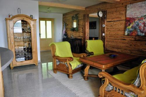 uma sala de estar com cadeiras verdes e uma mesa em Ferienwohnung Kochs Beeren em Oberfresen