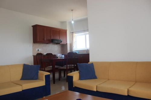 a living room with two couches and a dining room at Galatia's Court in Paphos City