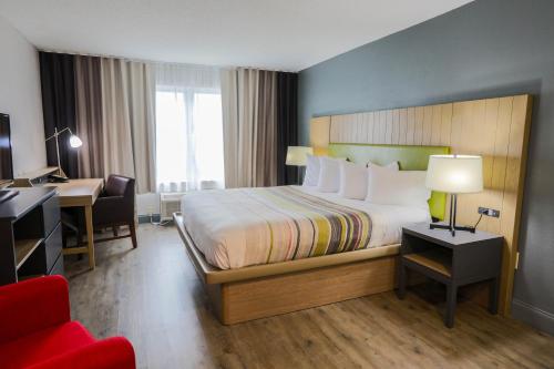 a hotel room with a bed and a desk and a chair at Country Inn & Suites by Radisson, Myrtle Beach, SC in Myrtle Beach