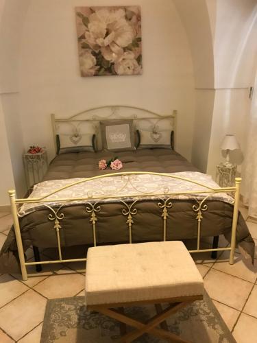 ファザーノにあるB&B La Collina Degli Uliviのベッドルーム1室(花の咲く大型ベッド1台付)