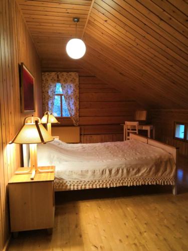 a bedroom with a bed in a wooden cabin at Rehto in Rovaniemi