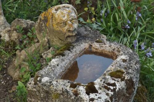 una estatua de una cabeza con un espejo en un jardín en Au coeur de soissons 1, en Soissons