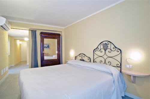 a bedroom with a large white bed and a table at Locanda della Maria in Bellagio