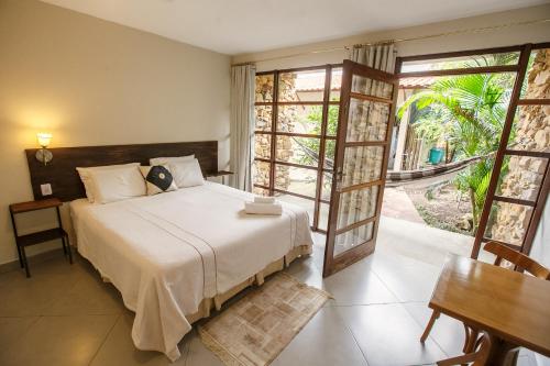 a bedroom with a bed and an open door at Pousada Zazen in Vale do Capao