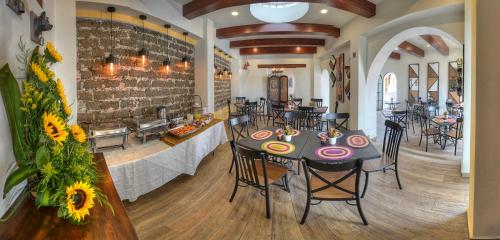 a dining room with tables and chairs and a brick wall at Hotel Santa Paula in Taxco de Alarcón