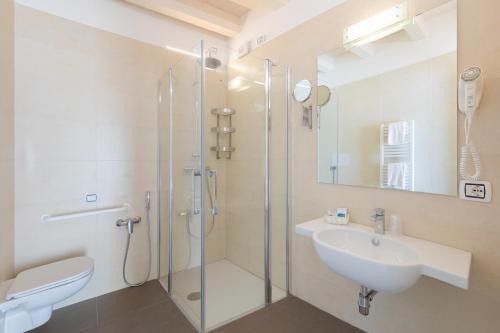 a bathroom with a glass shower and a sink at Hotel Garni' Serena in Caorle
