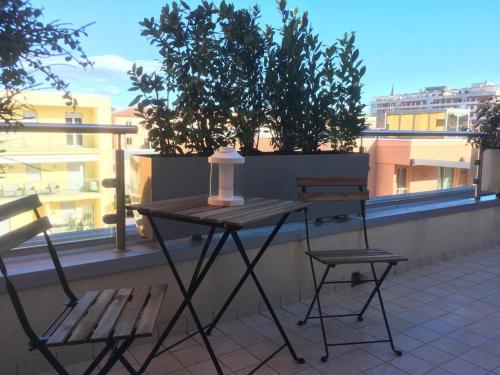 a picnic table and two chairs on a balcony at L`ATTICO Apartments in Civitanova Marche