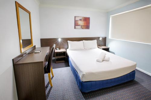 a small hotel room with a bed and a desk at Hunts Hotel Liverpool in Liverpool