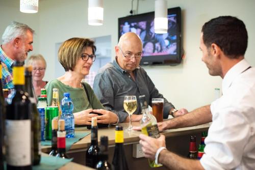 a group of people sitting around a bar with wine bottles at Astoria Galilee Hotel in Tiberias