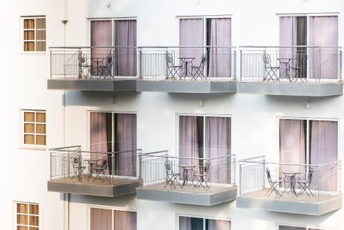 a building with balconies with tables and chairs on it at Astoria Galilee Hotel in Tiberias