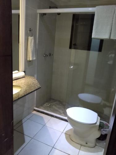 a bathroom with a toilet and a glass shower at Hotel Pousada Laje de Itauna in Saquarema