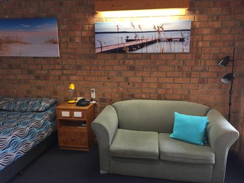 a room with a couch and a bed and a lamp at Kadina Gateway Motor Inn in Kadina