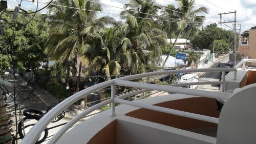 a balcony with palm trees on a city street at Aparta Hotel Caribe Paraiso in Juan Dolio