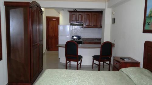 a kitchen with a table and chairs in a room at Aparta Hotel Caribe Paraiso in Juan Dolio
