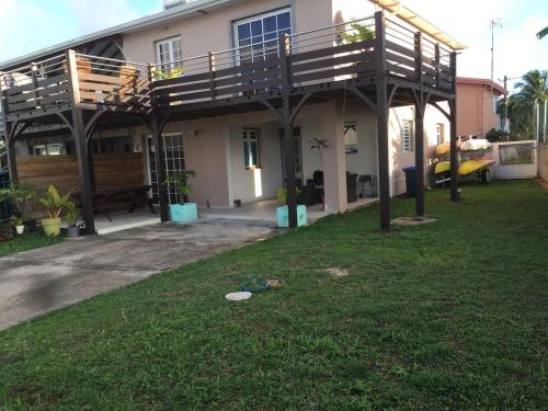 a house with a deck on top of a yard at CHIRIJIEN BLÉ in Le Robert