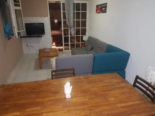 a living room with a blue couch and a table at CHIRIJIEN BLÉ in Le Robert