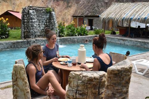 a group of women sitting around a table by a pool at Oasis Paraiso Ecolodge in Cabanaconde