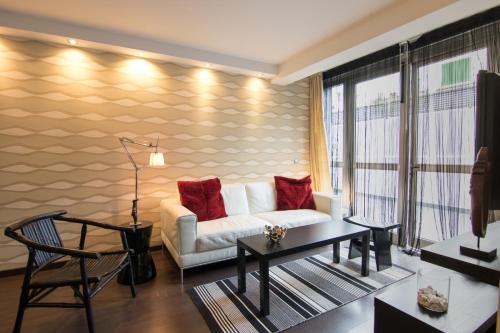 a living room with a white couch and red pillows at Warhol in Las Palmas de Gran Canaria