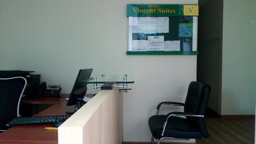 an office with a counter with chairs and a sign on the wall at Vincent Suites Hotel in Pasto
