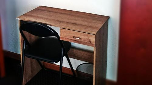 a wooden desk with a black chair next to it at Vincent Suites Hotel in Pasto