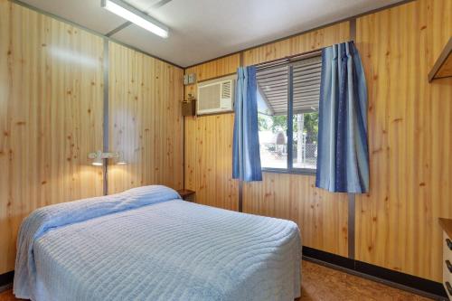 a bedroom with a bed and a window at First City Caravilla in Cairns