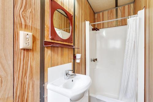 a bathroom with a sink and a toilet and a mirror at First City Caravilla in Cairns