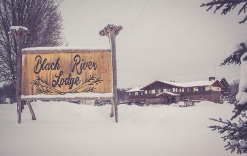 a sign in the snow in front of a house at North Ironwood Acres - Black River Lodge in Ironwood