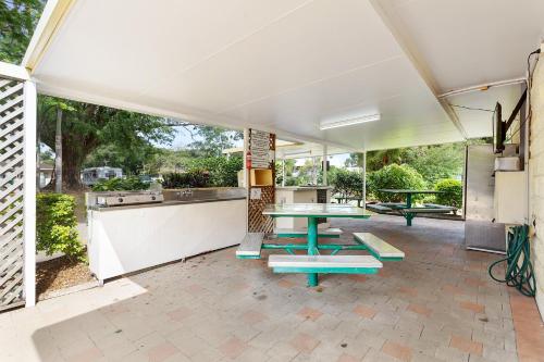 a patio with a table and picnic benches at First City Caravilla in Cairns