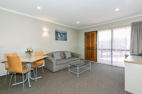 a living room with a couch and a table at Fairley Motor Lodge in Napier
