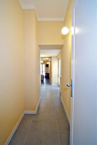a hallway with yellow walls and a tile floor at Locanda della Maria in Bellagio