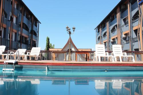 - un groupe de chaises blanches installées à côté de la piscine dans l'établissement A2Sea Hotel ,SHA Plus Certified, à Jomtien Beach