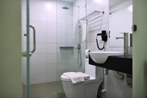 a bathroom with a toilet and a sink and a shower at Hotel Mornington Bukit Permata Lumut in Lumut