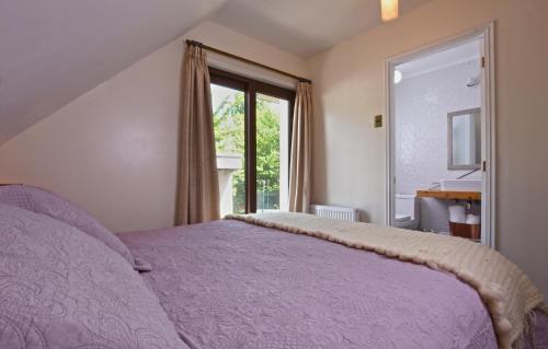 a bedroom with a purple bed and a window at Abriga Bed and Breakfast in Coihaique