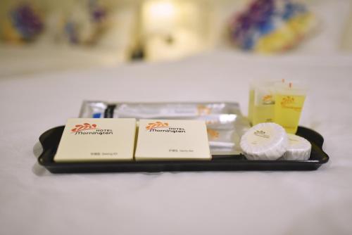 a tray with two cards and other items on it at Hotel Mornington Bukit Permata Lumut in Lumut