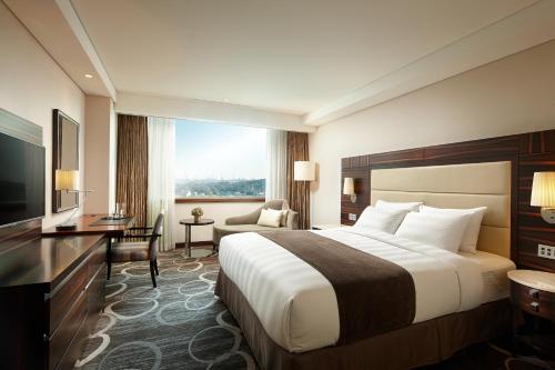 a hotel room with a large bed and a window at Lotte Hotel Ulsan in Ulsan