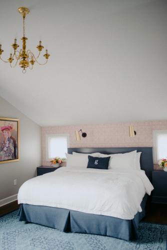 a bedroom with a large white bed and two windows at The Germantown Inn in Nashville