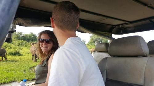 a man and a woman standing in a vehicle looking at elephants at Yonan River Face Safari Resort in Udawalawe
