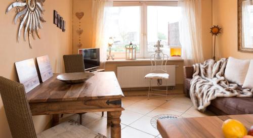 シャルボイツにあるAltes Strandhus Kl.App Casa Ostseeのリビングルーム(木製テーブル、ソファ付)