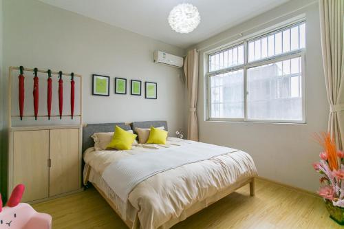 a bedroom with a bed with yellow pillows and a window at Xi'an Lianhu·Longshou Business Circle· Locals Apartment 00154940 in Xi'an